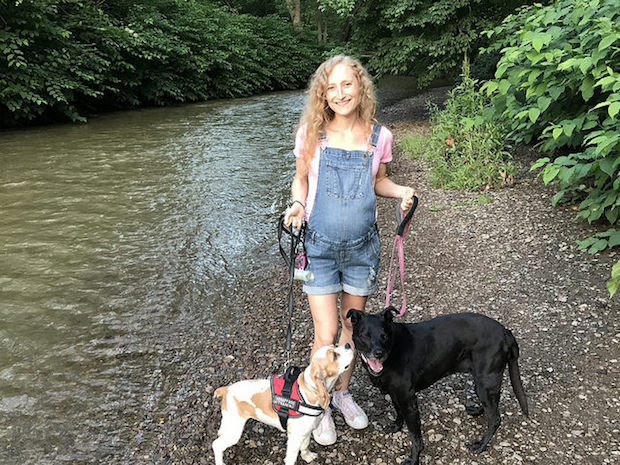 Girl with dogs by water