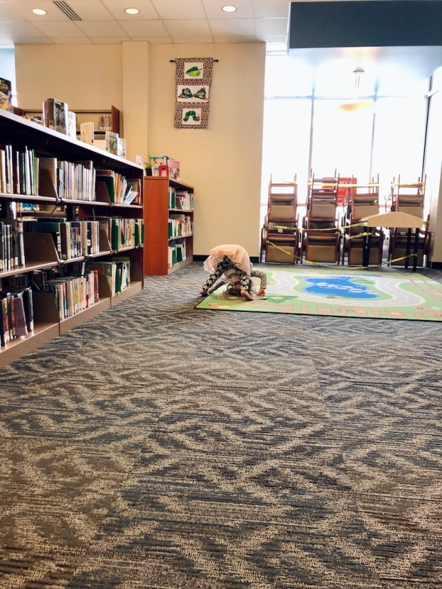 Toddler girl doing roll at library