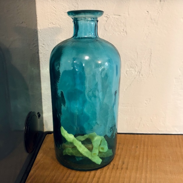 Blue glass vase with veggie straws in it