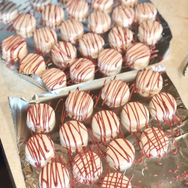 Chocolate covered Oreos with white chocolate and maroon drizzle