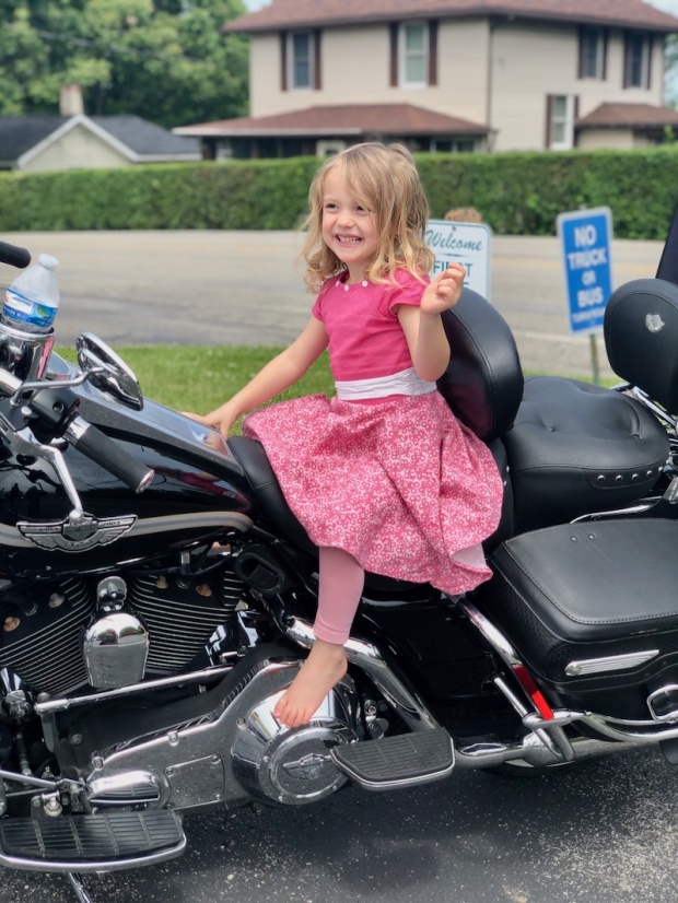 Toddler girl sitting on a Harley Davidson motorcycle
