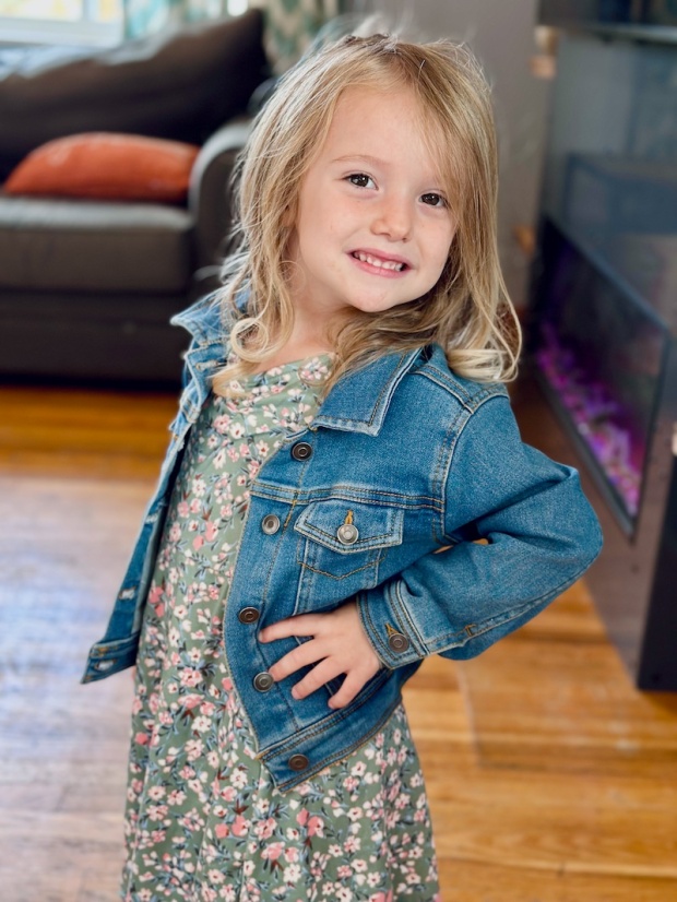Four year old wearing dress and denim jacket